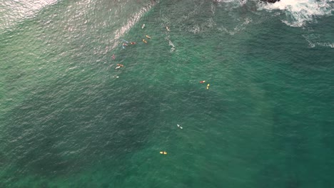 Drone-view-surfers-riding-waves-at-Carrizalillo-beach,-Puerto-Escondido,-Oaxaca,-Mexico