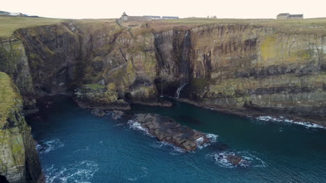 Drone-Shot-Panorámica-Cruzar-Los-Acantilados-Y-La-Cascada-En-Whaligoe-En-Escocia,-Reino-Unido