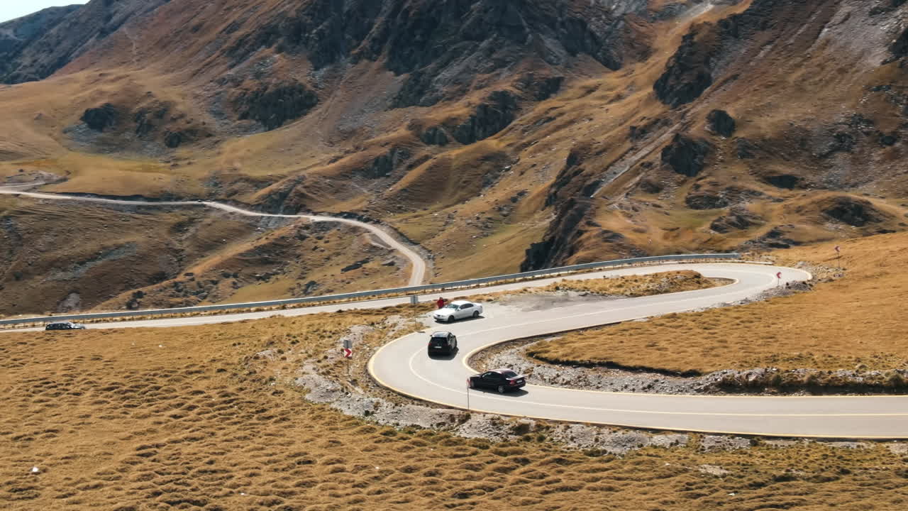 Aerial drone view of nature in Romania. Carpathian mountains, sparse vegetation, Transalpina road with cars