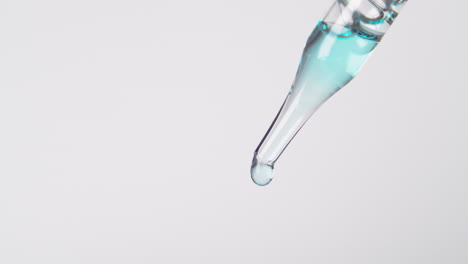 simple dropper and droplet with light blue liquid and white background