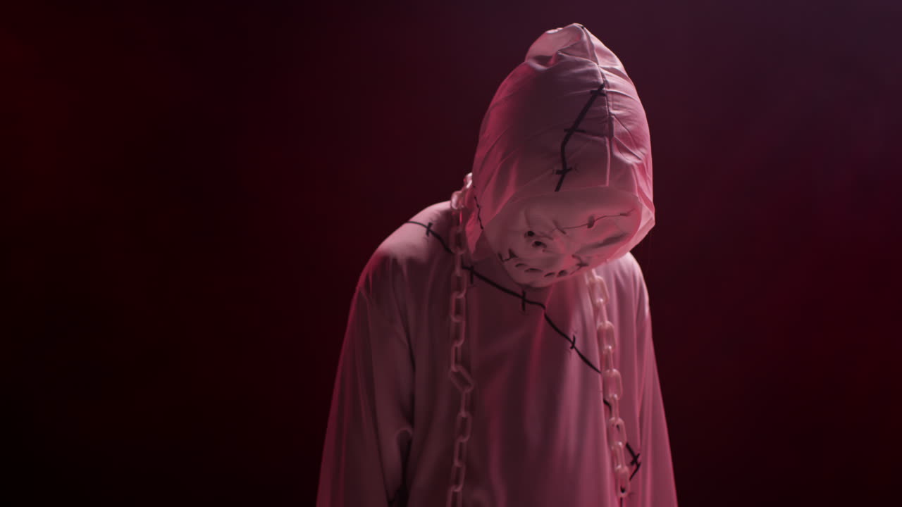 ребёнок в костюме призрака зомби монстра трюк или угощение на хэллоуин пугает людей на фоне красного дыма 2