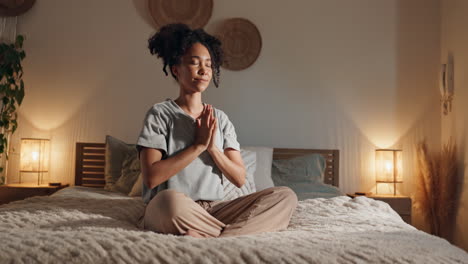 woman meditating on bed