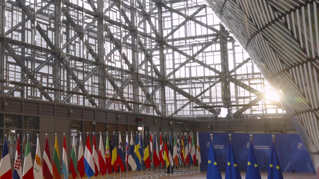 Sunrise with EU flags and European member state flags inside the EU council building in Brussels, Belgium