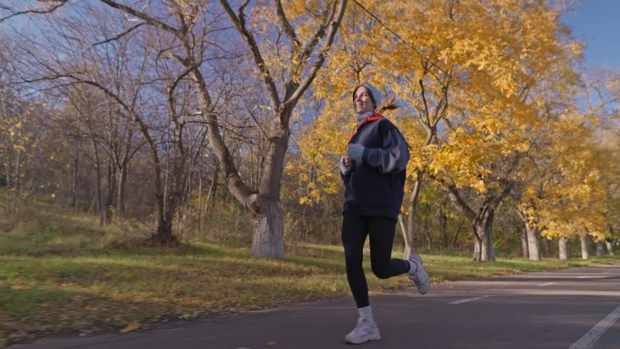 Donna che corre nel parco autunnale