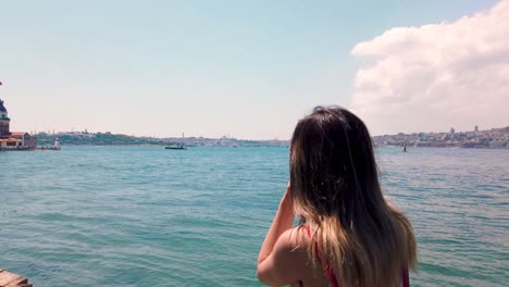 hermosa chica toma fotografías del bósforo y la torre de las doncellas en la ciudad de uskudar, estambul, turquía