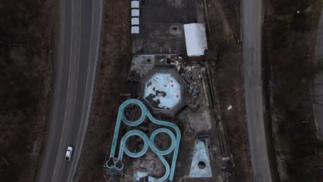 top down aerial drone footage of an abandoned water park with slides and swimming pools