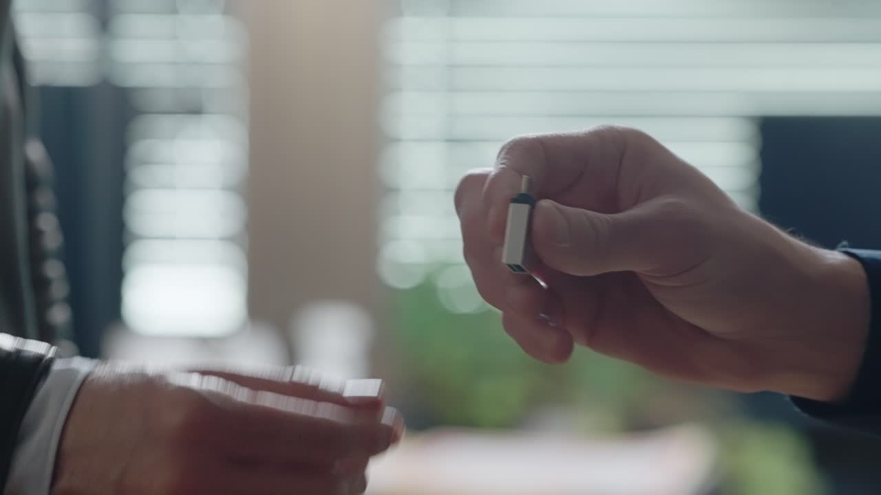 Hands discreetly passing a small USB drive, followed by a handshake. Confidential data transfer, secret exchange, or potential digital theft. cybersecurity, corporate secrecy, crime-related dealings.