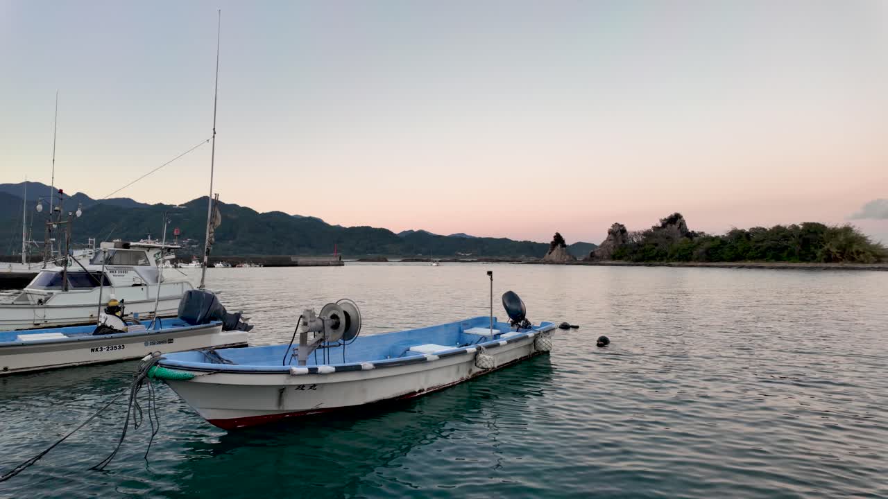 Boats gently floating in Nachi Bay with Benten Island in the background, capturing the serene atmosphere of the golden hour