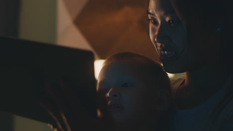 mother and child enjoying tablet time at night