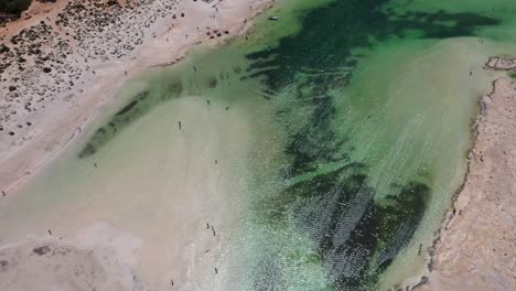 Top-down-view-of-Balos-Beach-and-Lagoon-with-turquoise-water,-mountains-and-cliffs-in-Crete,-Greece-by-aerial-drone