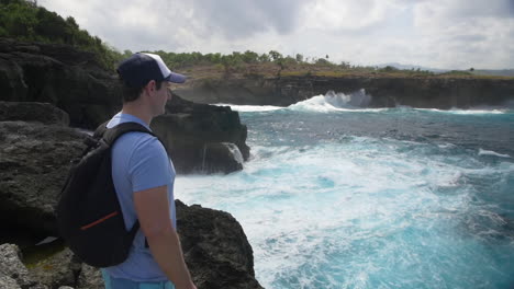 Man-Looking-at-Waves-Crashing-and-White-Water-at-edge-of-Rock---Not-Safe-to-Swim