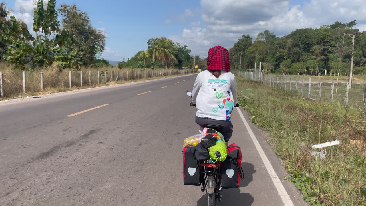 Bella inquadratura di donne in bicicletta per le strade del Laos.