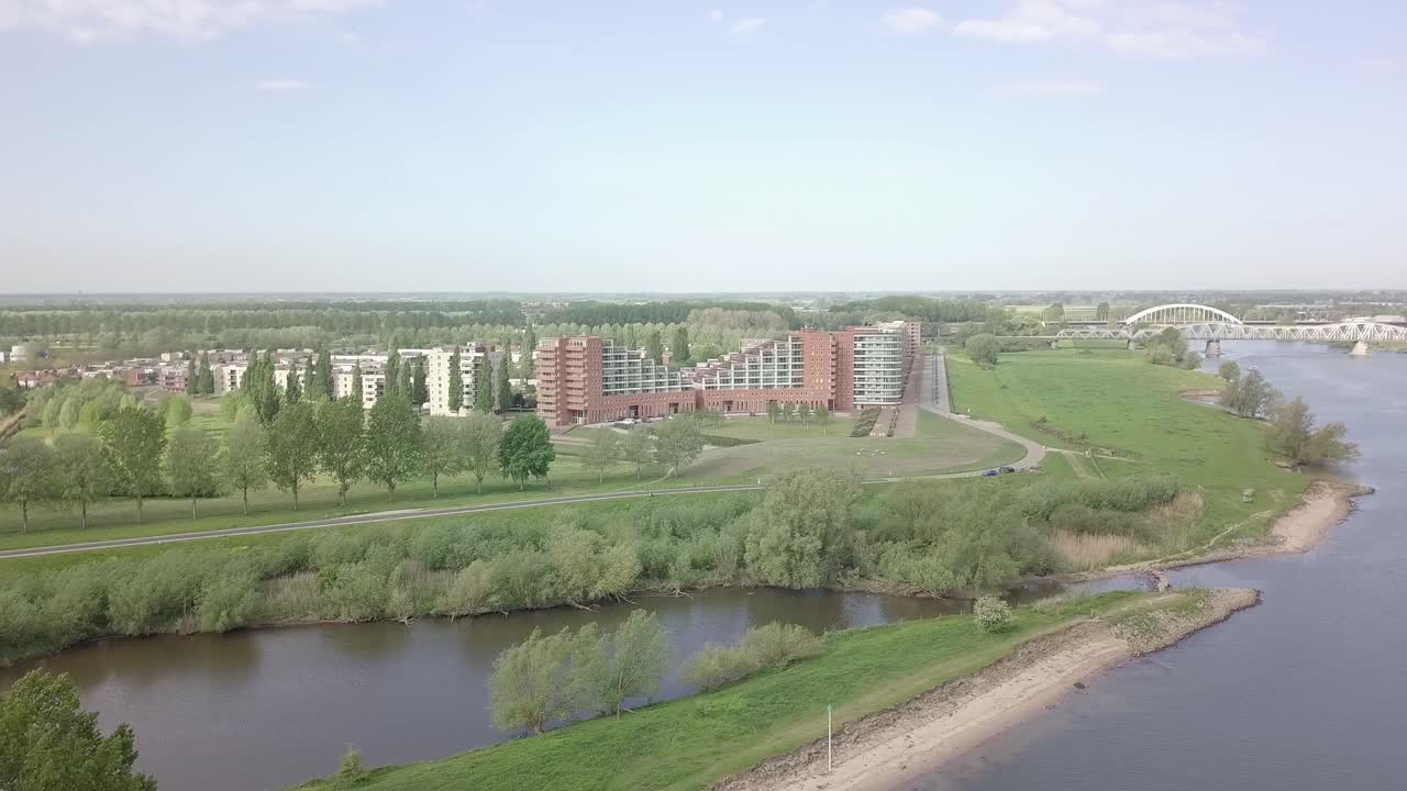 вид с воздуха на загородный поселок рядом с озером и рекой, полный квартир и домов