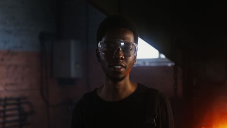 man in safety glasses in a workshop