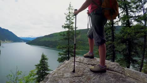 Cheerful-mature-woman-standing-on-rock-4k