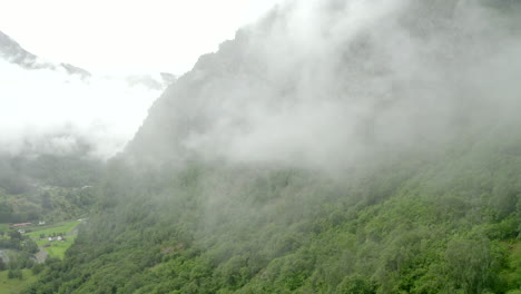 Areal-shoot-of-drone-gaining-hight-and-rising-next-to-a-Cliffside-in-could