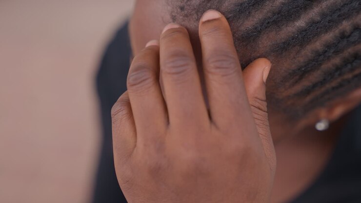 Black girl touching hairline and braids with fingers, calming preperformance ritual with focused hand movement, closeup of scalp and nails, subtle tension release, warm skin tones
