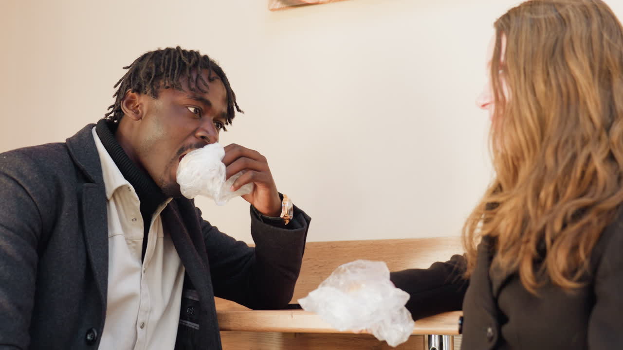 Side view of blonde hair covering female figure indoors as man interacts nearby, showing calm body language, gentle focus capturing natural candid moment filled with warmth and subtle intimacy