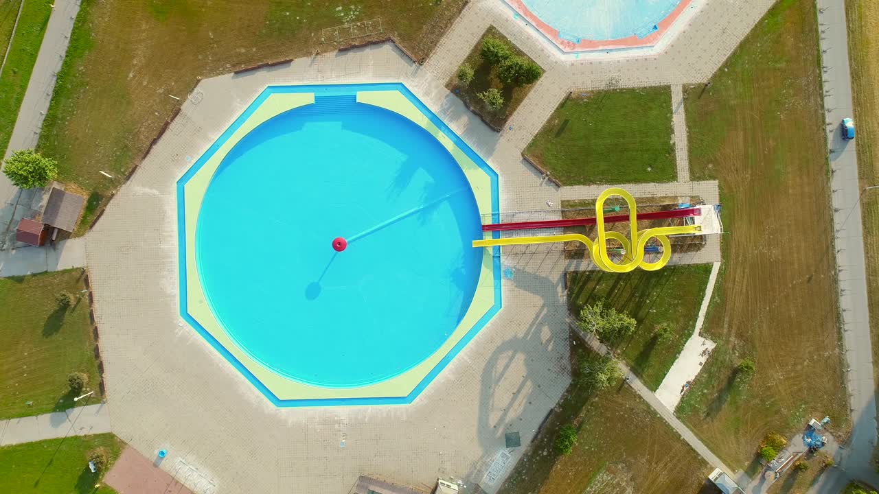 vista aérea de piscinas vacías con toboganes en un parque acuático abandonado.
