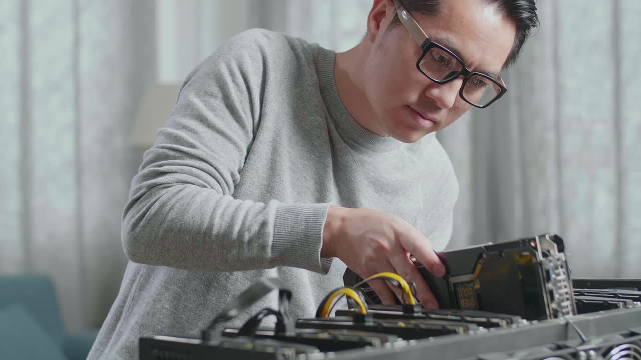 un hombre asiático con gafas construye la plataforma de minería para la minería de criptomonedas.