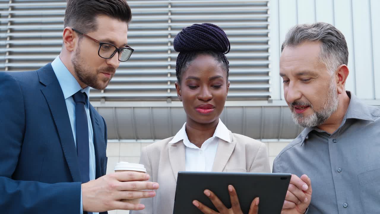 거리에서 태블릿으로 무언가를 읽는 아프리카계 미국인 사업가와 백인 사업가 2명의 클로즈업 보기