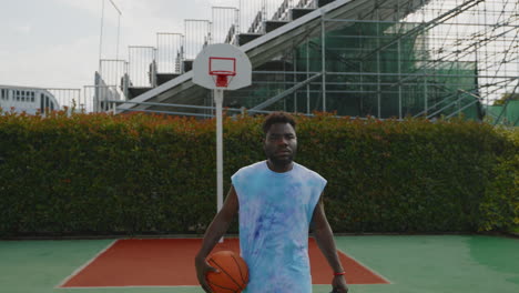 man holding a basketball on a street court