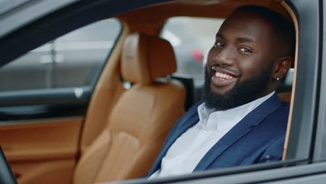 African-man-rolling-window-down-at-car