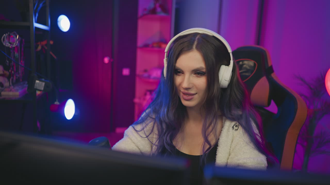 close up of curious girl wearing headphones playing video game in neon lit studio with condenser mic at desk and dual monitors, focused smile, immersive colorful setup, ambient atmosphere