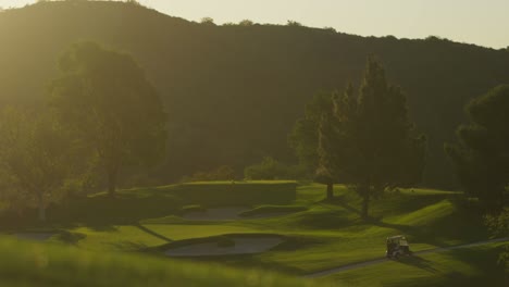 Weite-Sicht-Auf-Einen-Golfwagen,-Der-Entlang-Eines-Golfplatzes-Fährt