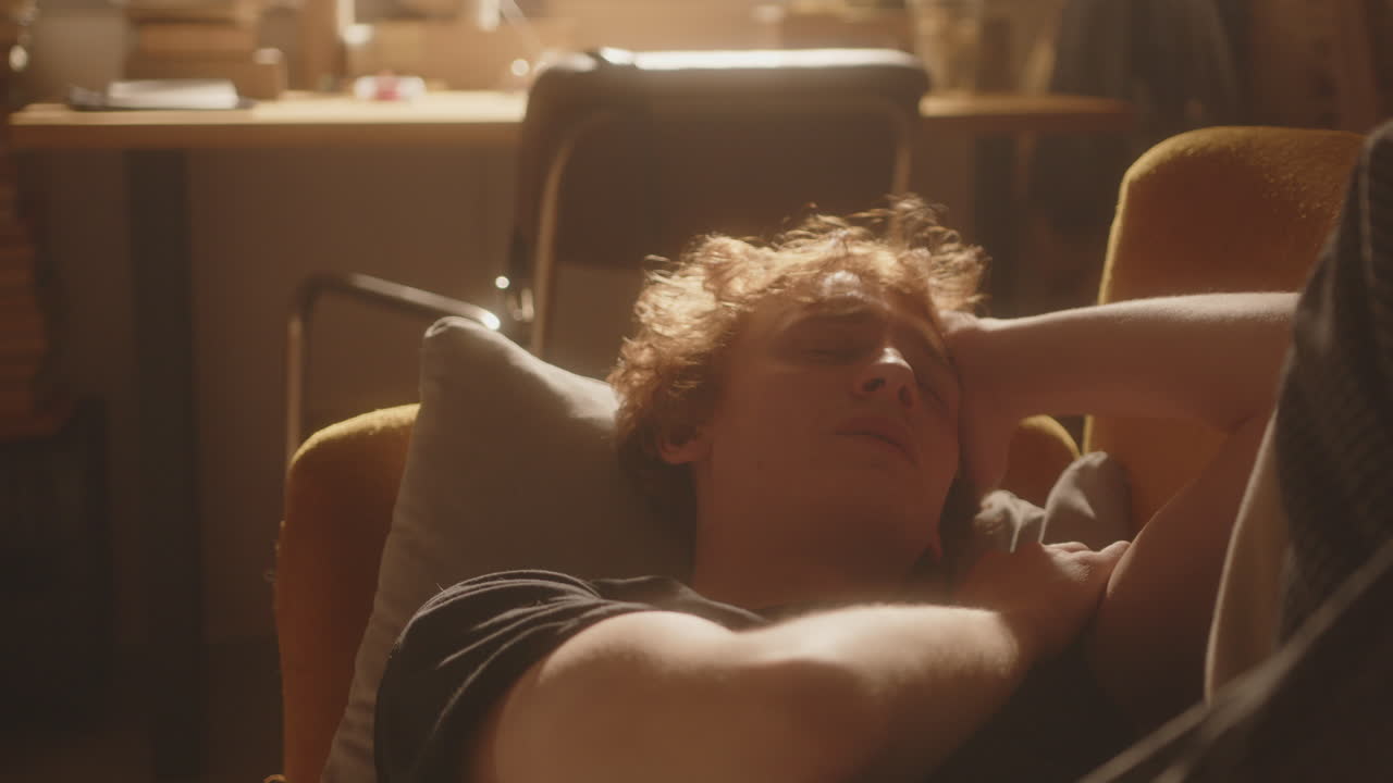 hombre deprimido tendido en el sofá, llorando y sintiendo agotamiento emocional