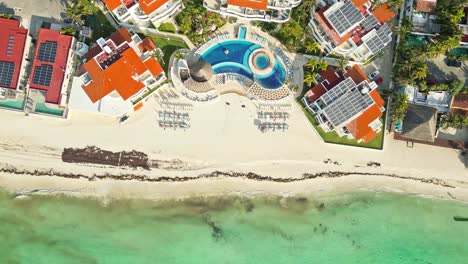 beachfront resorts with pools and loungers on sunny playa del carmen shoreline