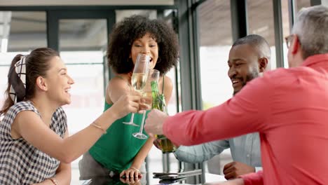 team of diverse happy colleagues toasting drinks together at office