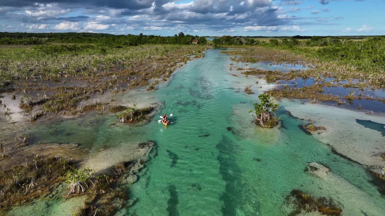 vista aérea de personas remando en los rápidos de bacalar, en el soleado méxico - reversa, disparo de drones