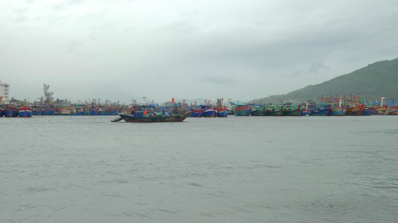 เรือประมงลำหนึ่งแล่นผ่านท่าจอดเรือไปอย่างช้าๆ ในวันที่พายุเข้าและลมแรง