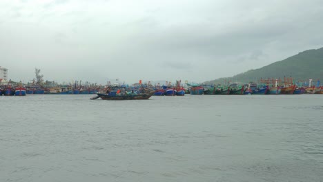 un barco de pesca pasa lentamente por el puerto deportivo en un día tormentoso y ventoso