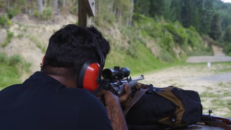 a person on shooting range learning how to fire a rifle