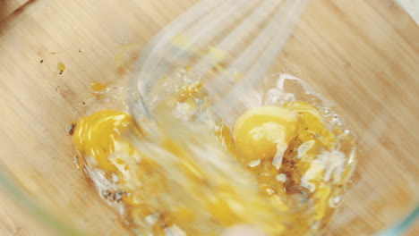 beating raw eggs in kitchen prep