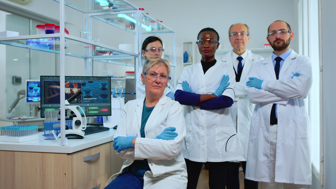Multiethnic team of experienced scientists looking at camera