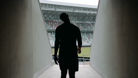 atlético afroamericano de raza negra entrando en el estadio antes del entrenamiento matutino. fotografiado con lente anamórfica