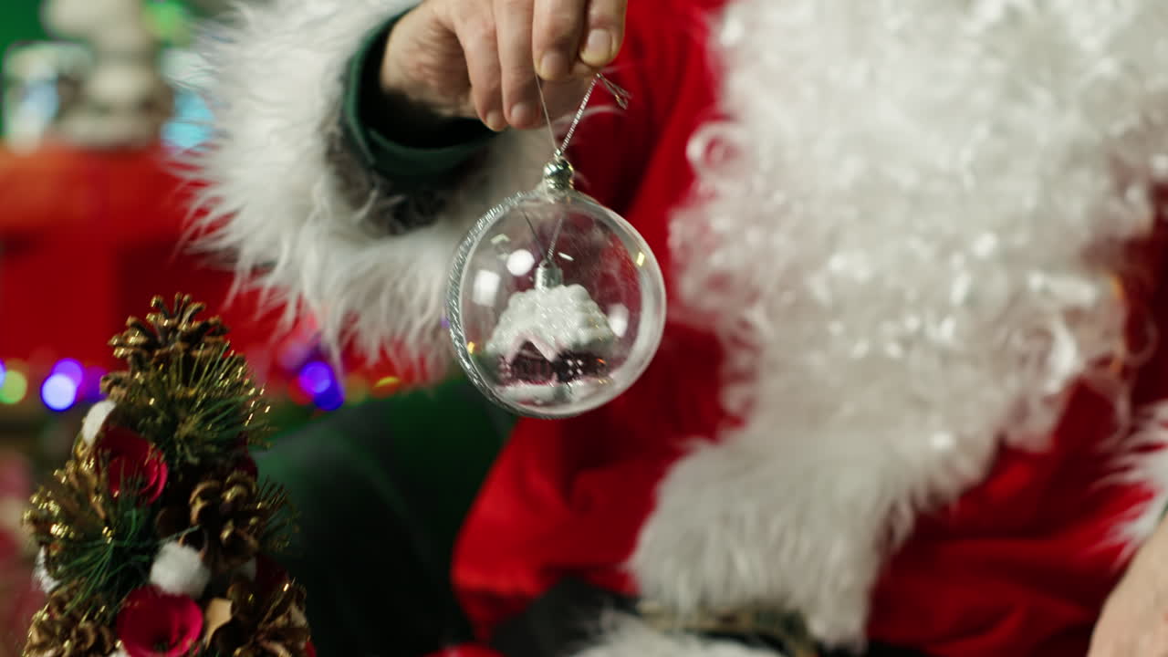 산타클로스가 크리스마스 장식을 들고 있다