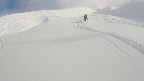 Mann-Fährt-Abseits-Der-Piste-Auf-Einem-Sonnigen-Berg-Ski,-Mit-Blauem-Himmel-Und-Sessellift-Im-Hintergrund