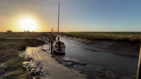 Boat-docked-in-the-estuary-with-evening-golden-sunlight