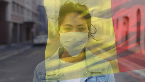 animation of flag of belgium waving over woman wearing face mask during covid 19 pandemic