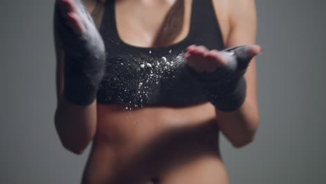 Close-Up-view-of-young-beautiful-fit-woman-dusting-powder-on-her-hands-wrapped-in-boxing-tapes-as-she-prepares-for-a-workout-at