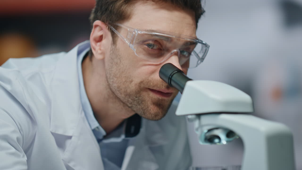 Biotechnology specialist looking microscope making scientific research close up.