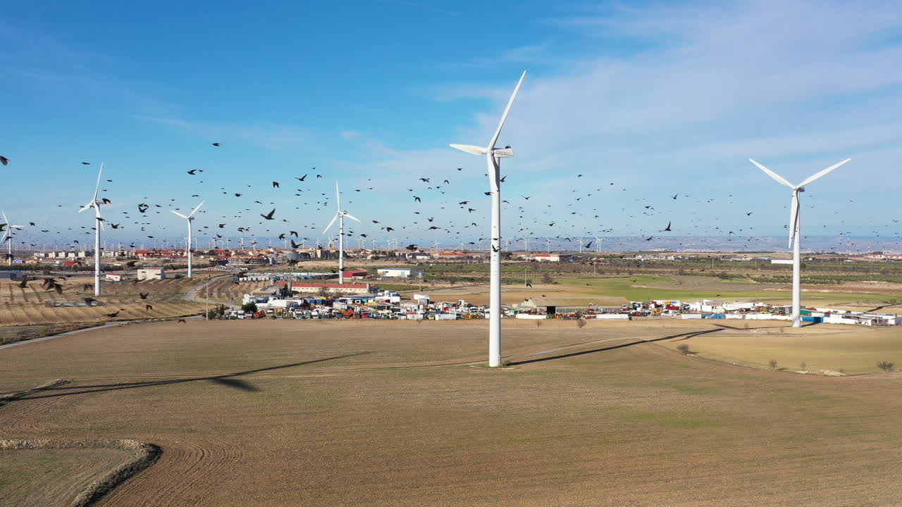 스페인의 풍력 터빈과 새 무리가 배경에 있는 라 무엘라 쓰레기 매장