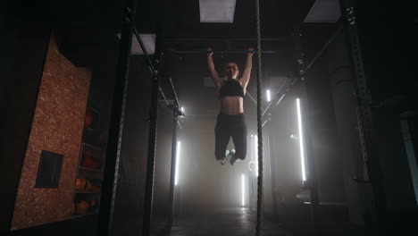 athletic-woman-is-doing-pull-up-on-crossbar-in-gym-slow-motion-shot-of-swaying-female-body