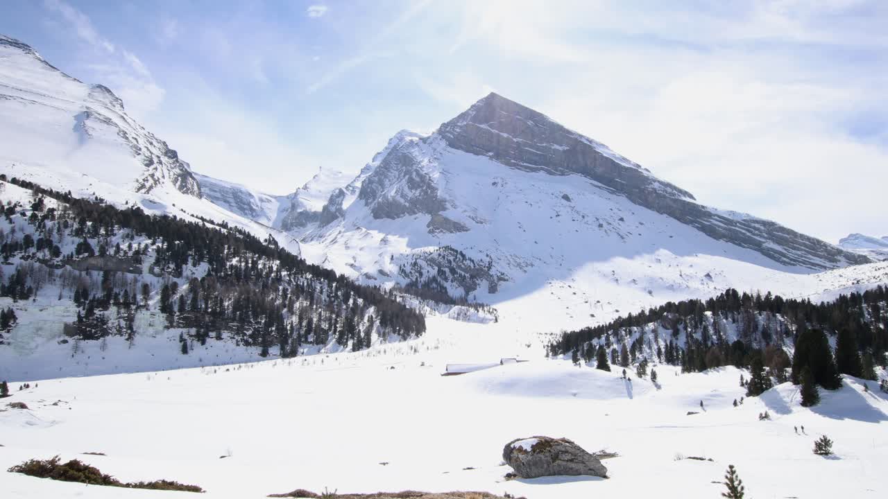 Offroad car driving across winter mountain landscape, wide establisher