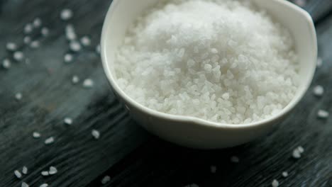 Bowl-of-salt-on-dark-desk-