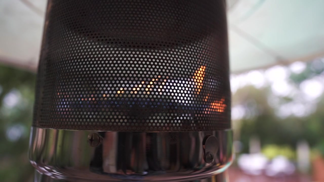 Zeitlupenaufnahme eines brennenden Terrassenheizers in einem Restaurant, kleine Flammen im Inneren zum Wärmen an kalten Tagen und für gemütliches Beisammensein, Nahaufnahme